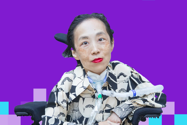 Photo of Alice Wong, an Asian American disabled woman in a power chair. She is wearing a black blouse with a floral print, a bold red lip color and a trach at her neck. Photo credit: Eddie Hernandez Photography.